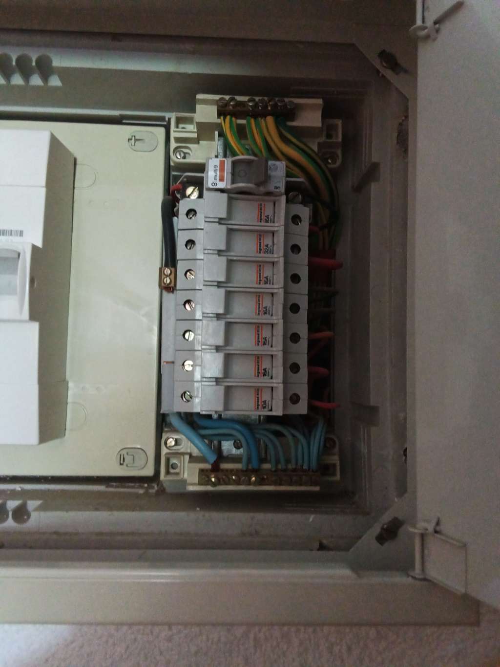 Intérieur d'un coffret électrique : peigne d'alimentation, bornier de terre et bornier de neutre
